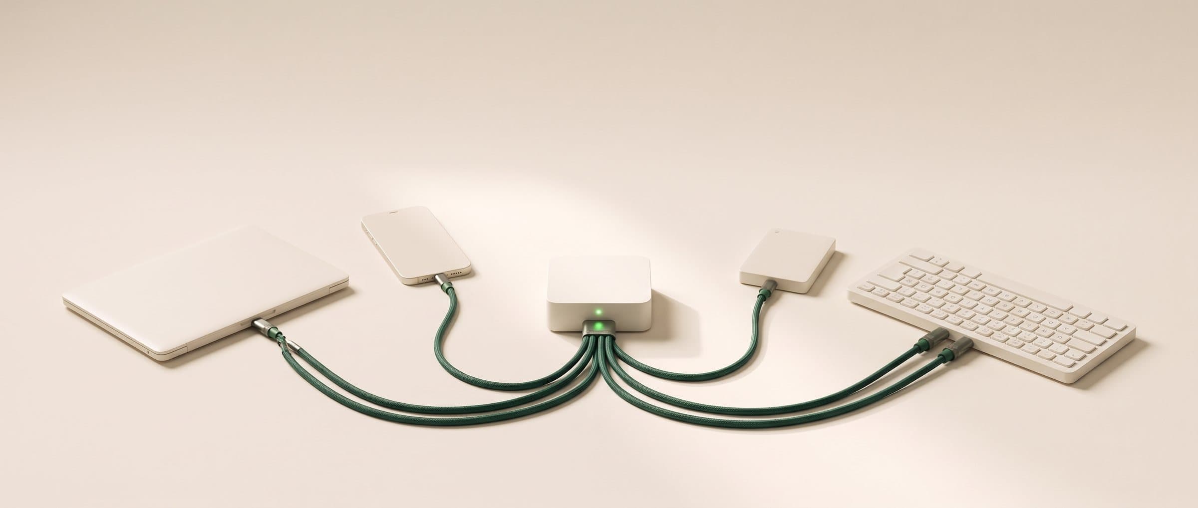 Petit boîtier blanc à lumière verte relié par des câbles verts à un ordinateur, un téléphone, un disque et un clavier